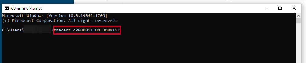 The traceroute path command and placeholder production domain typed into the Command Prompt program.